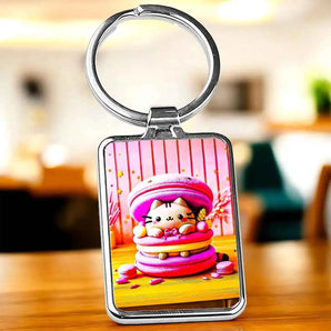 Porte-clés rectangulaire en métal argenté avec motif de chat kawaii dans un macaron rose et jaune.