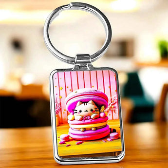 Porte-clés rectangulaire en métal argenté avec motif de chat kawaii dans un macaron rose et jaune.