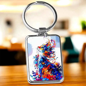 Porte-clés rectangulaire en métal argenté avec motif chat coloré.
