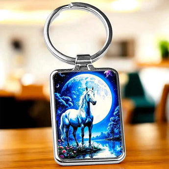 Porte-clés argenté avec illustration d'un cheval blanc devant une pleine lune bleue.
