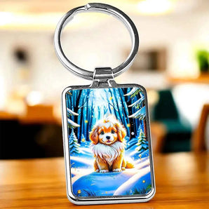 Porte-clés carré en métal avec illustration de chiot dans un paysage hivernal enneigé.
