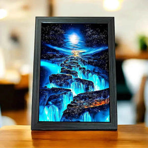 Tableau encadré d'un paysage nocturne bleuté, cascade et ciel étoilé.