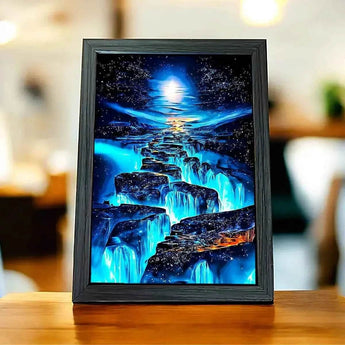 Tableau encadré d'un paysage nocturne bleuté, cascade et ciel étoilé.