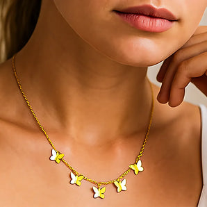 Collier Papillon Or fin avec plusieurs pendentifs papillons porté sur le cou d'une femme