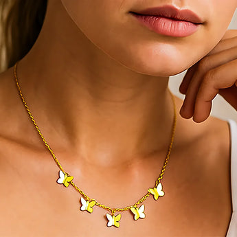 Collier Papillon Or fin avec plusieurs pendentifs papillons porté sur le cou d'une femme